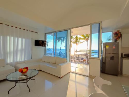 - un salon avec un canapé blanc et une table en verre dans l'établissement Hotel Portoalegre, à Coveñas