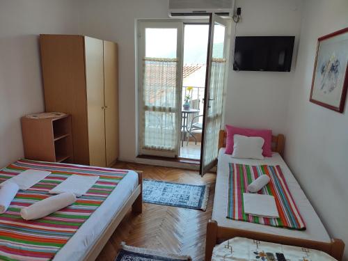 a small room with two beds and a balcony at Smestaj Vella in Herceg-Novi