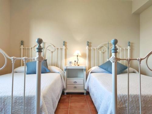 a bedroom with two beds and a table with a lamp at Desconectaengalicia La Lanzada, 200m playa in A Lanzada