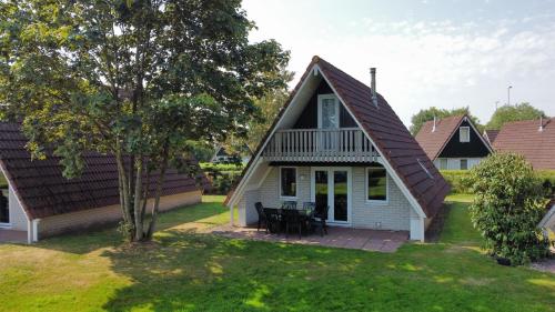 a small white house with a gambrel roof at Gezellig vakantiehuis 't Gramsbergje in Gramsbergen
