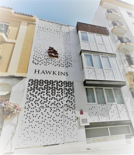 Un edificio bianco con un cartello che legge Hawkins di Suite by Hawkins Exterior BB a Algeciras