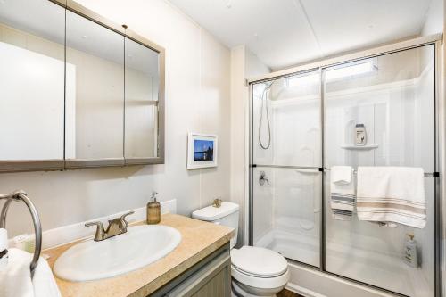 La salle de bains blanche est pourvue d'un lavabo et d'une douche. dans l'établissement Hoodsport Hideaway, à Hoodsport
