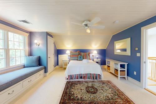 a blue bedroom with a bed and a couch at Spinnaker Trail in Orleans