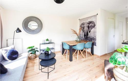 a living room with a table and blue chairs at Stunning Home In Heinkenszand With Wifi in Heinkensand