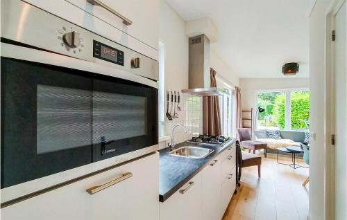 a kitchen with a sink and a microwave at Stunning Home In Heinkenszand With Wifi in Heinkensand