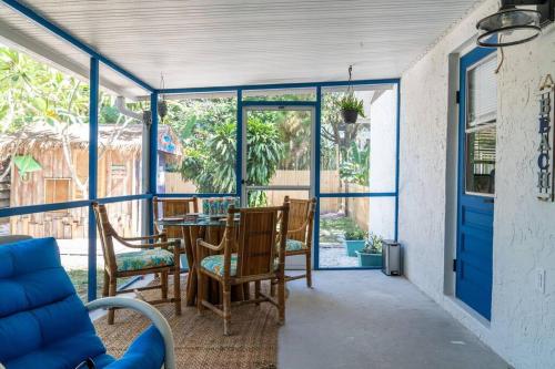eine abgeschirmte Veranda mit einem Tisch und Stühlen in der Unterkunft Welcome to The Bray Escape 4 miles to Siesta Key in Sarasota