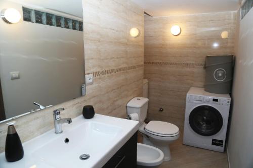 uma casa de banho com um lavatório e uma máquina de lavar roupa em Appartamento Dante em Catânia