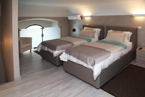 Un dormitorio con 2 camas y una silla. en Appartamento Dante, en Catania