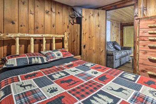 Blockhausschlafzimmer mit einem Bett und einem Stuhl in der Unterkunft Lakefront Minocqua Cabin with Dock and Fire Pit! in Minocqua