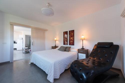 テルデにあるHolidays & Health in Finca Oasis - APART 2のベッドルーム(白いベッド1台、黒い椅子付)