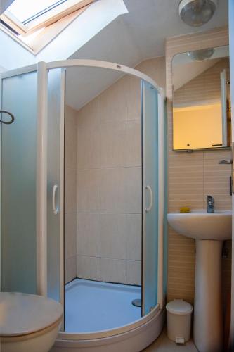 a bathroom with a glass shower and a sink at Smestaj Vella in Herceg-Novi