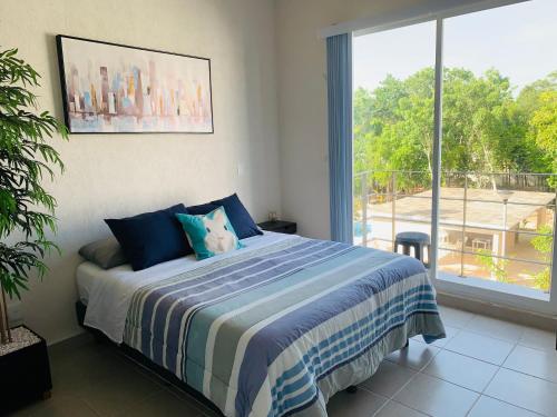 ein Schlafzimmer mit einem Bett und einem großen Fenster in der Unterkunft Franks House Luxury Apartment "Shared House" in Cancún