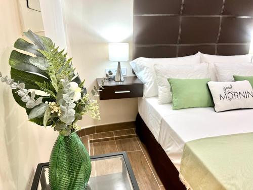 een kamer met een bed en een vaas met bloemen bij Front Arc in Barcelona