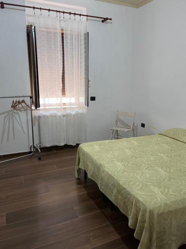 Vibo Apartment في فيبو فالينتيا: غرفة بيضاء مع سرير ونافذة