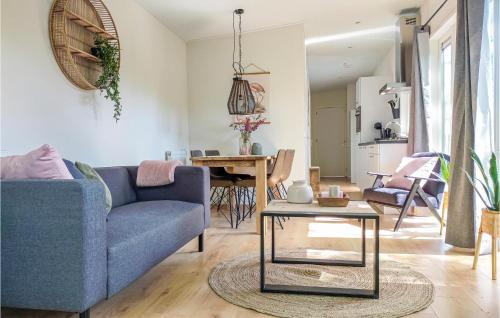 a living room with a blue couch and a table at 3 Bedroom Cozy Home In Heinkenszand in Heinkensand