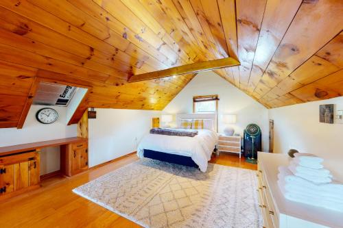 Stowe Hideout Unit 1 في ستو: غرفة نوم بسرير وسقف خشبي