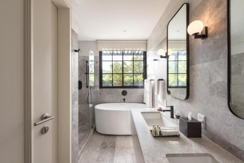 a bathroom with a tub and a large mirror at The Amsterdam by Viadora in Mexico City