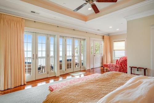 a bedroom with a bed and a chair and windows at The Ship's Bridge in Annapolis