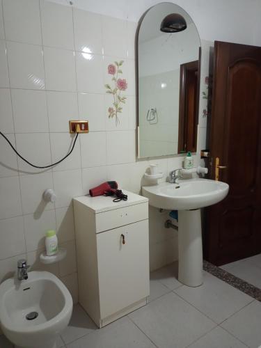 a bathroom with a sink and a toilet and a mirror at Il Salvatore in Masainas