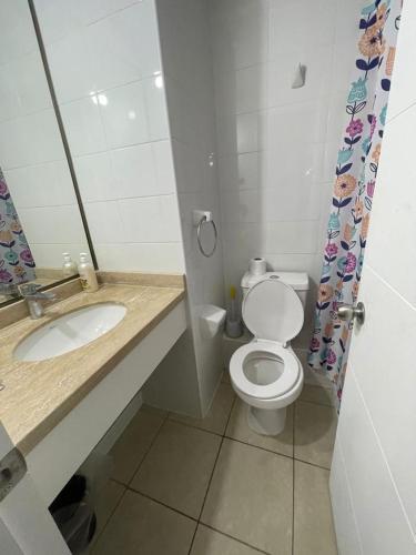 a bathroom with a white toilet and a sink at Edificio Gran Marino in Antofagasta