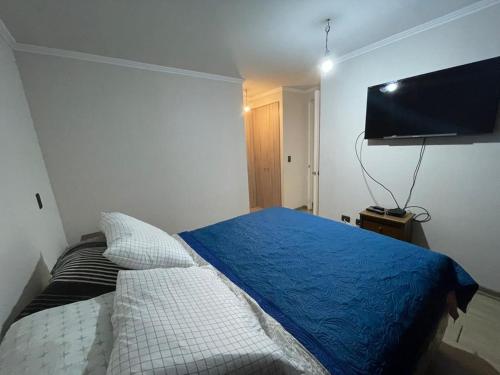 a bedroom with a bed and a flat screen tv at Edificio Gran Marino in Antofagasta