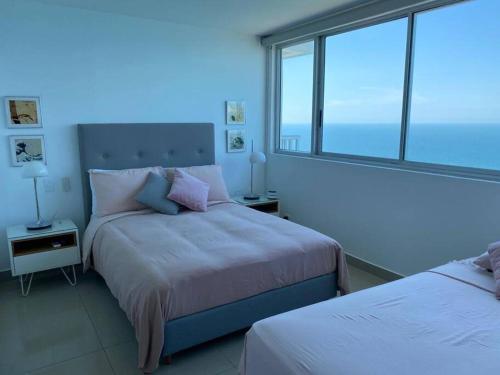 a bedroom with two beds and a large window at Palmetto2803 in Cartagena de Indias