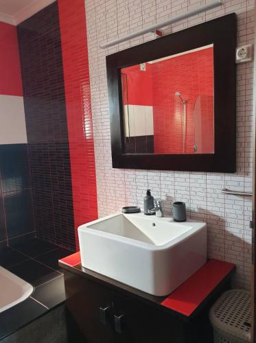 a bathroom with a white sink and a red mirror at Casa do Outeiro - AL in Praia da Vitória