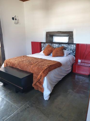 a bedroom with a large bed with a red headboard at Casa do Outeiro - AL in Praia da Vitória