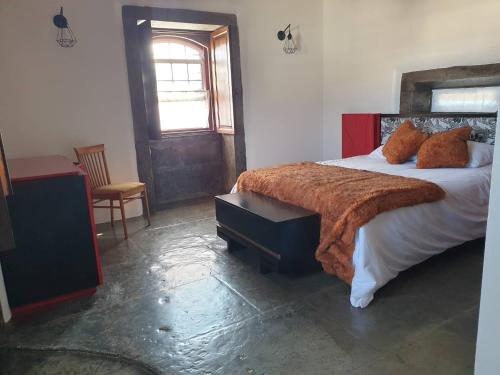 1 dormitorio con 1 cama con manta marrón en Casa do Outeiro - AL, en Praia da Vitória
