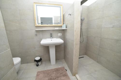 a bathroom with a sink and a toilet and a mirror at Beachfront Marilyn in Durrës