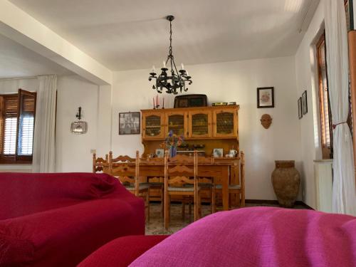 una sala da pranzo con tavolo e lampadario pendente di Villa Persefone - Splendida villa con giardino a Ficarazzi