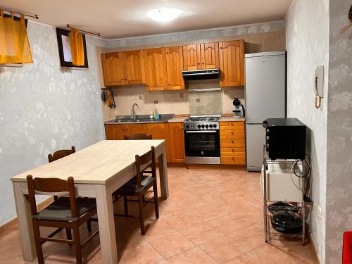 una cucina con armadi in legno, tavolo e frigorifero di holiday home a Vasto