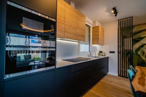 a kitchen with black and white cabinets and a sink at Catedral - Apartamentos Burgos Deluxe in Burgos