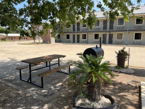 two picnic tables in front of a building at Coachway Inn in Luling