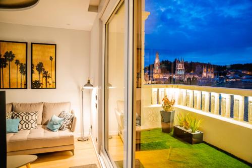 d'un balcon avec un canapé et une vue sur la ville. dans l'établissement Catedral - Apartamentos Burgos Deluxe, à Burgos