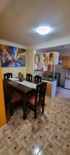 ein Esszimmer mit einem Tisch und Stühlen sowie eine Küche in der Unterkunft Casa Enea Pudahuel in Santiago