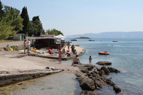 a group of people on a beach near the water at Apartments with parking spaces Klenovica, Novi Vinodolski - 7605 in Klenovica