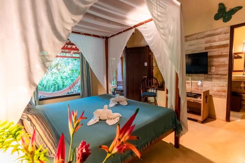 a bedroom with a canopy bed with a fish on it at Mata N'ativa Pousada in Trancoso