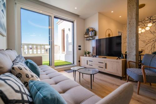a living room with a couch and a large window at Catedral - Apartamentos Burgos Deluxe in Burgos