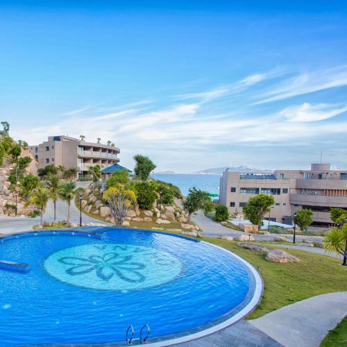 a large blue swimming pool in a resort at Ohana Village in Phương Phi