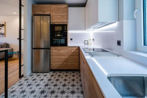 a kitchen with a sink and a refrigerator at Catedral - Apartamentos Burgos Deluxe in Burgos