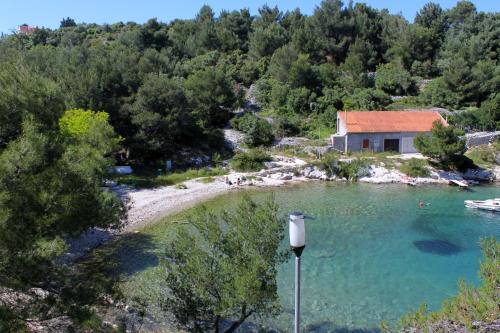 a view of a river with a house in the background at Apartments with a parking space Mali Losinj (Losinj) - 8059 in Mali Lošinj