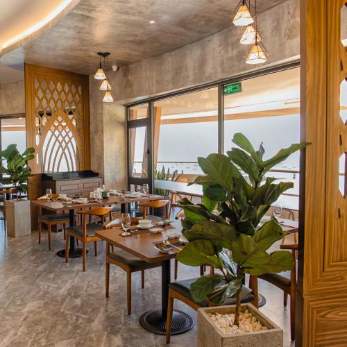 a restaurant with wooden tables and a potted plant at Ohana Village in Phương Phi