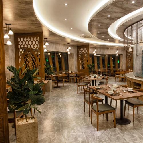 a restaurant with wooden tables and chairs and a ceiling at Ohana Village in Phương Phi