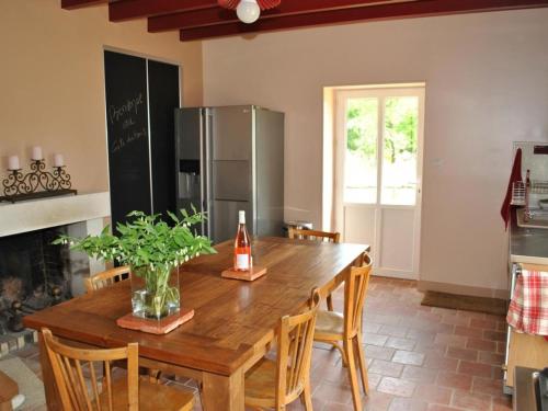 une cuisine avec une table en bois et un réfrigérateur dans l'établissement Maison de Vigneron Restaurée avec Jardin Clos, Équipement Complet, au Cœur d'une Forêt - FR-1-381-218, à Razines