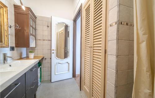 baño con lavabo y puerta con espejo en 2 Bedroom Cozy Home In Camogli en Camogli