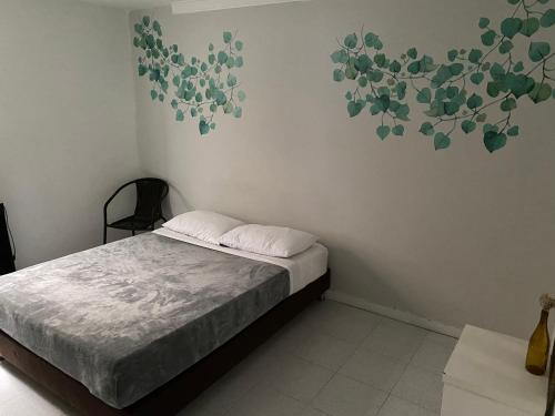 a bedroom with a bed and a painting on the wall at Cocobamboo Hotel in Medellín