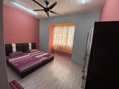 莎阿南的住宿－Homestay Ria Shah Alam/Subang，一间卧室配有一张床和吊扇
