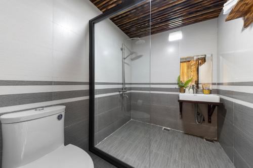 a bathroom with a shower and a toilet and a sink at Chapa Farmstay - Mountain Retreat in Sa Pa