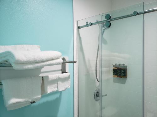 a bathroom with a shower and white towels at Calafia Inn San Clemente Newly renovated in San Clemente